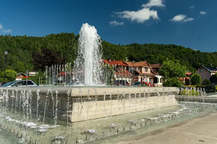Muszyna rynek fontanna na tle gorskiego krajobrazu